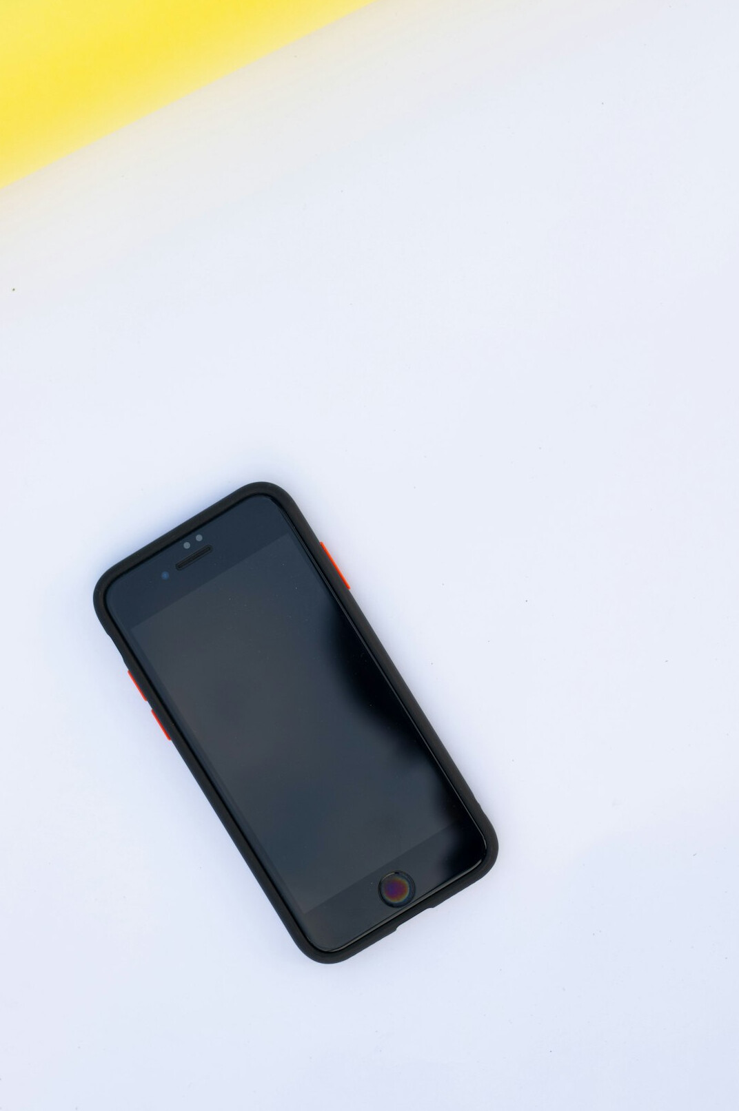 Smartphone showing an email inbox on a desk