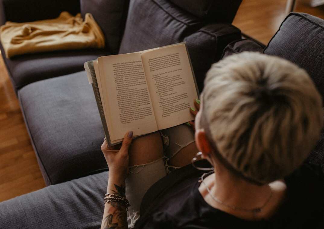 person reading book at home
